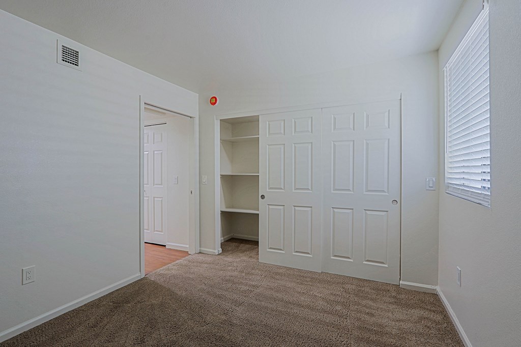 A room with a carpeted floor and a white door.