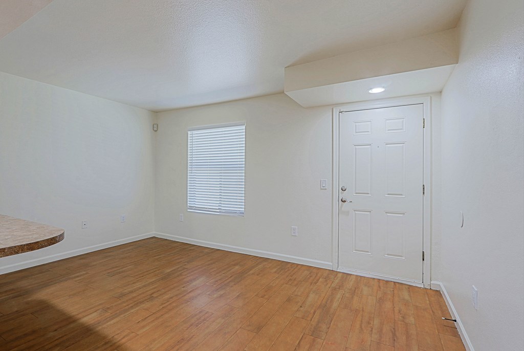 A room with a white door and a window with blinds.