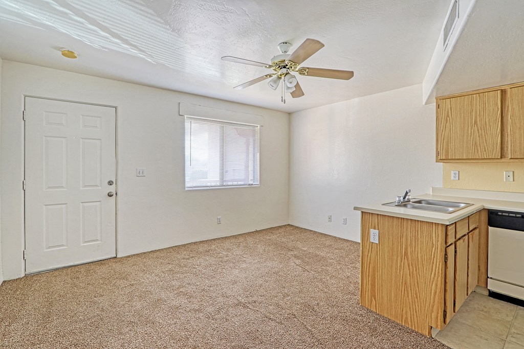 an empty kitchen with a sink and a ceiling fan