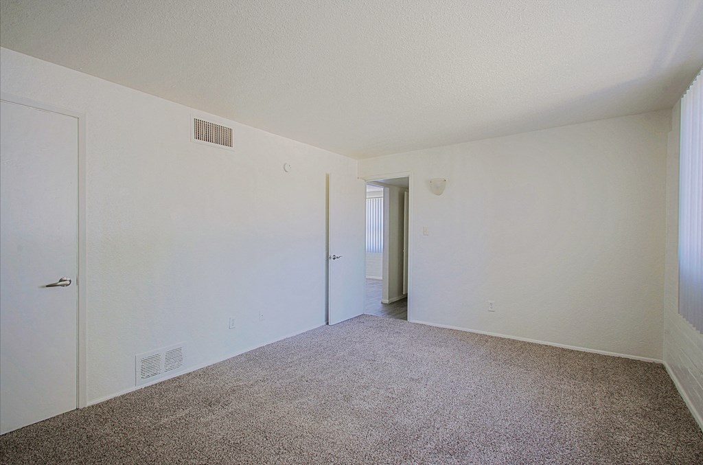 a bedroom with a carpeted floor and white walls