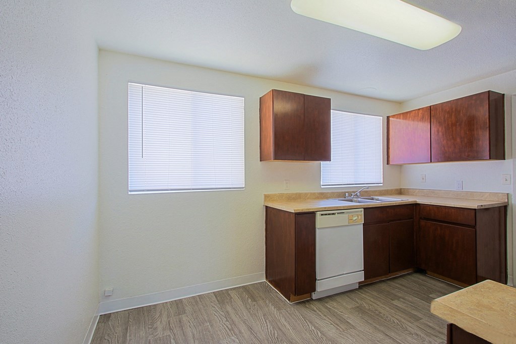 a kitchen with brown cabinets and a white dishwasher
