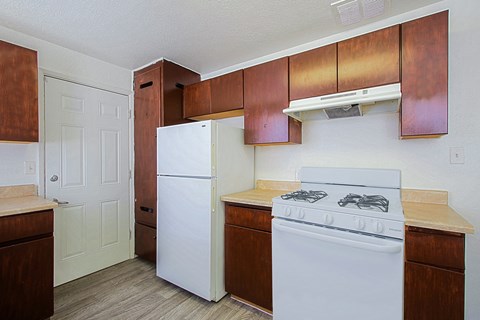 a kitchen with white appliances and wooden cabinets and a white refrigerator
