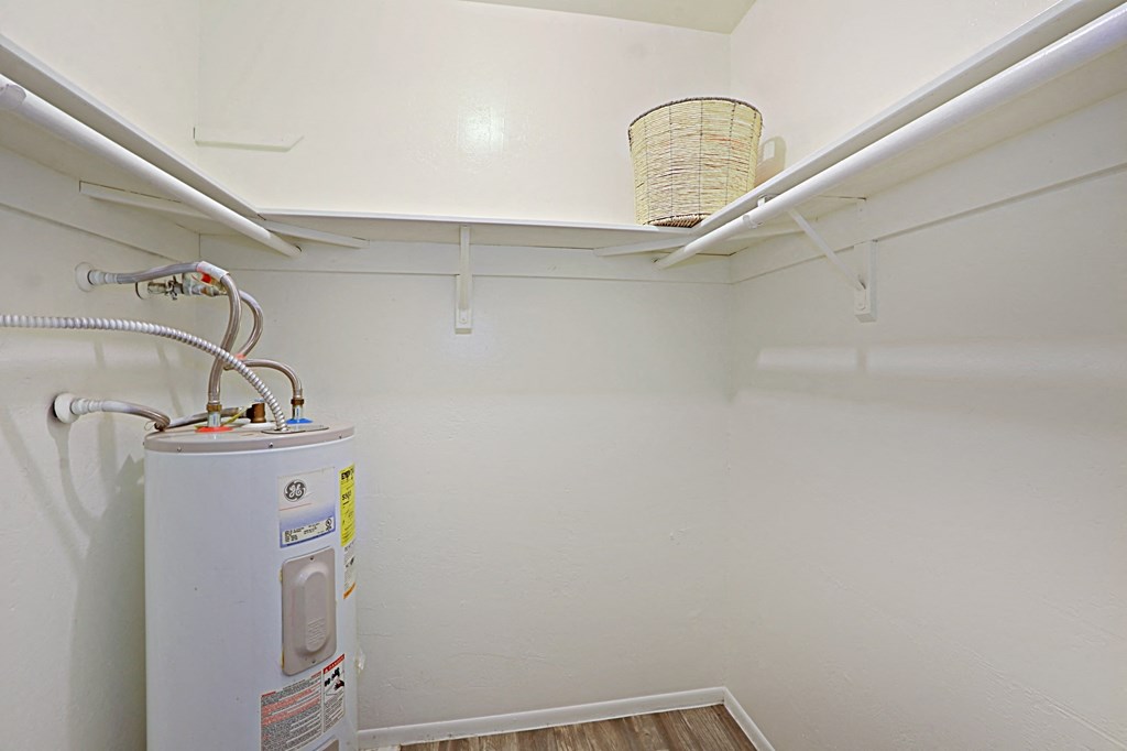 a laundry room with a washer and dryer and a shelf with a basket on top