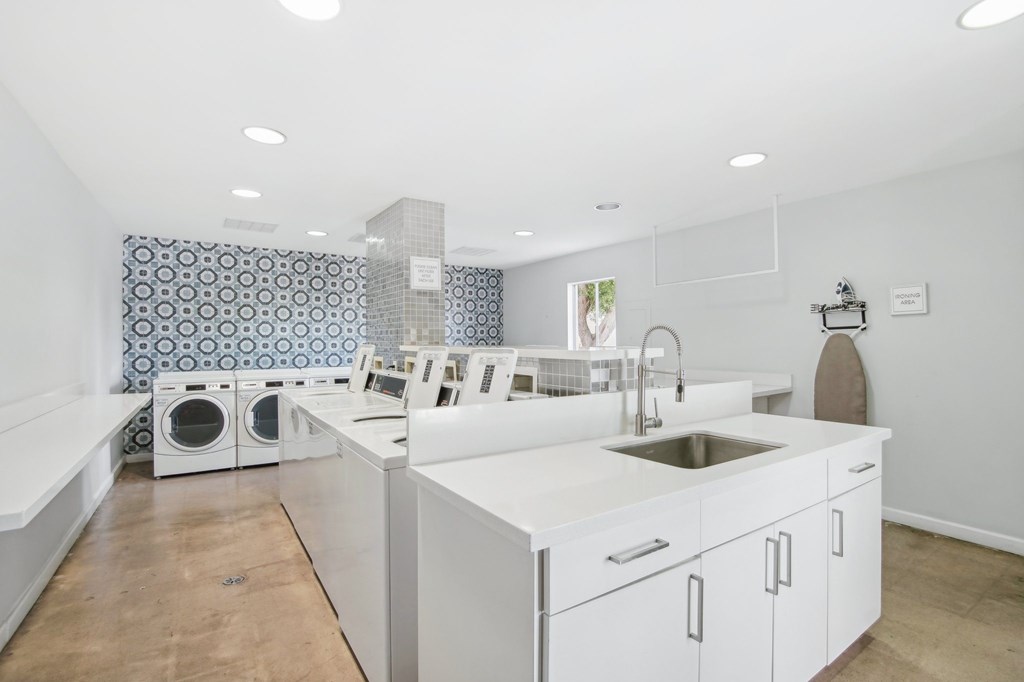 A kitchen with a white counter top and a sink. at The Viridian Apartments, Scottsdale, Arizona