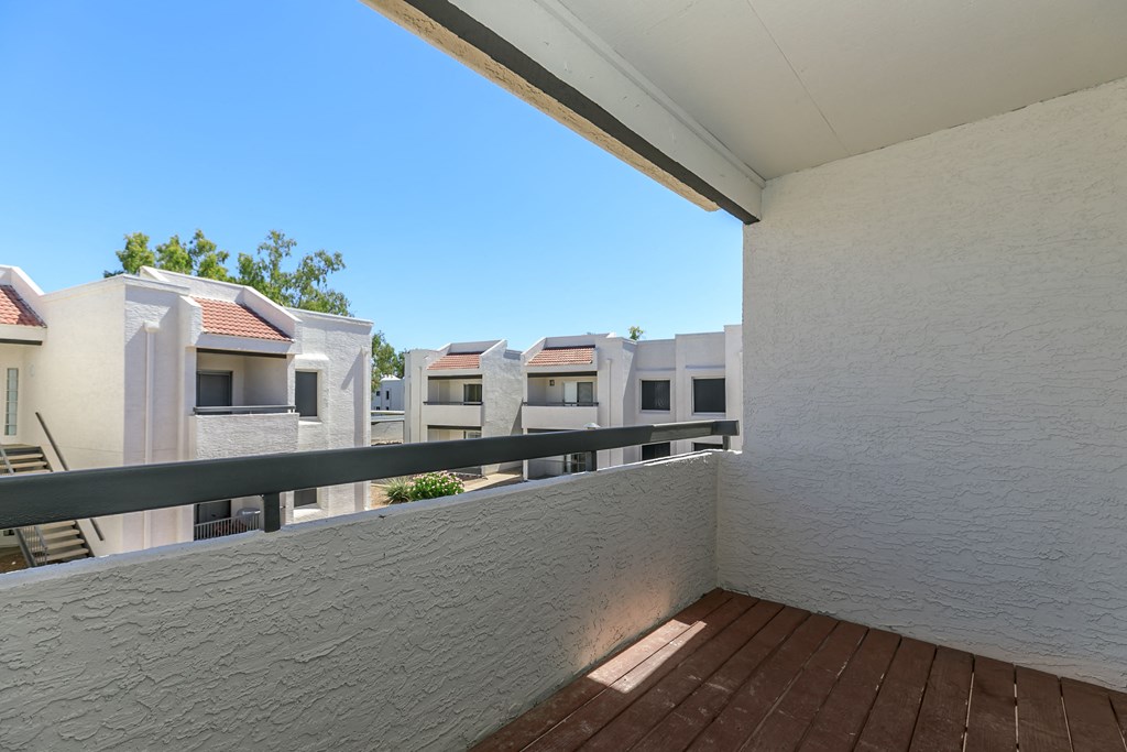 a balcony or terrace with a wood floor and a white wall at Tides on Southern, Mesa, 85204