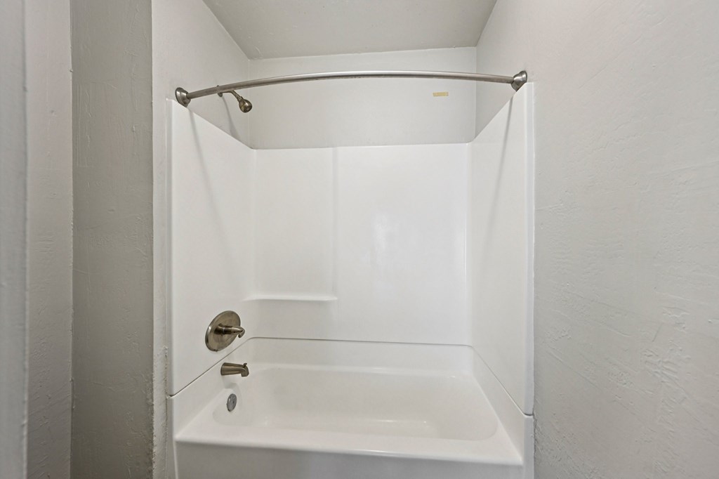 A white bathroom with a shower and tub.