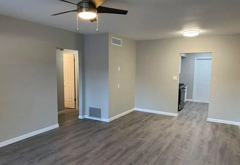 an empty living room with a ceiling fan