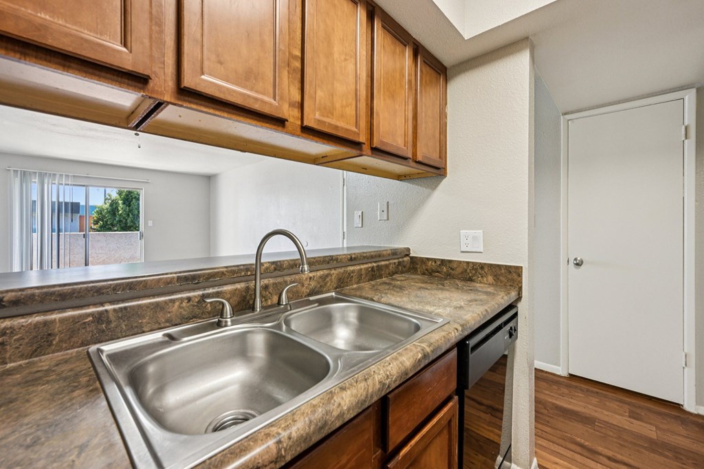 A kitchen with a sink and wooden cabinets.