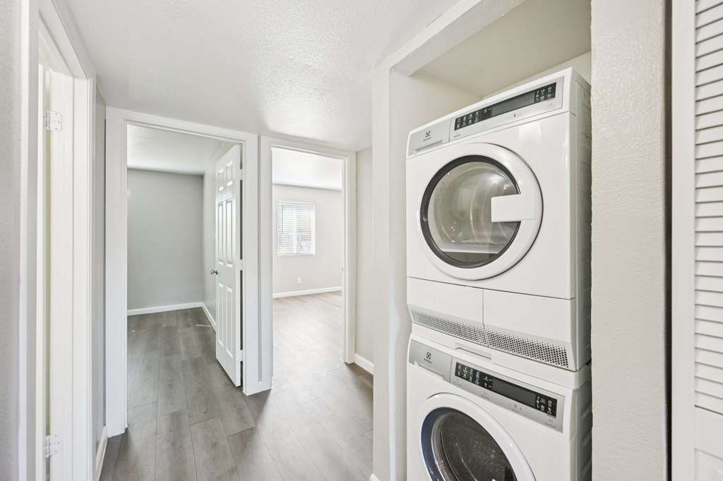 A white washing machine and dryer in a laundry room.