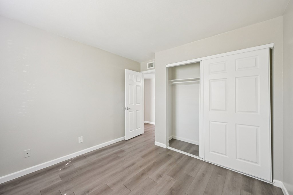 A room with a white door and a white closet.