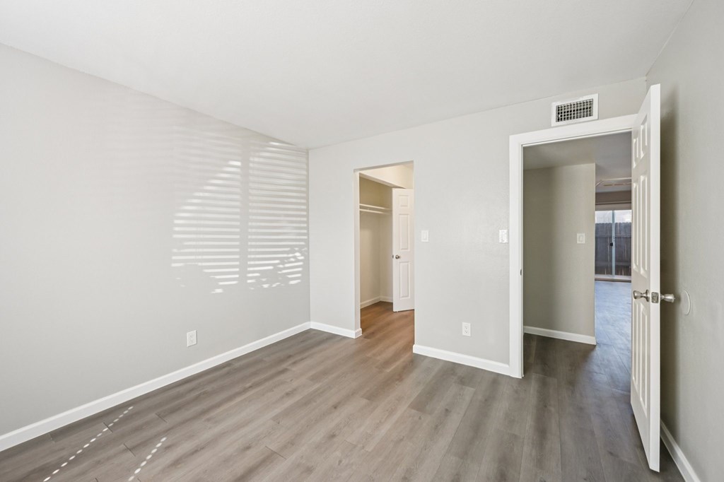 A room with a white door and a window with blinds.