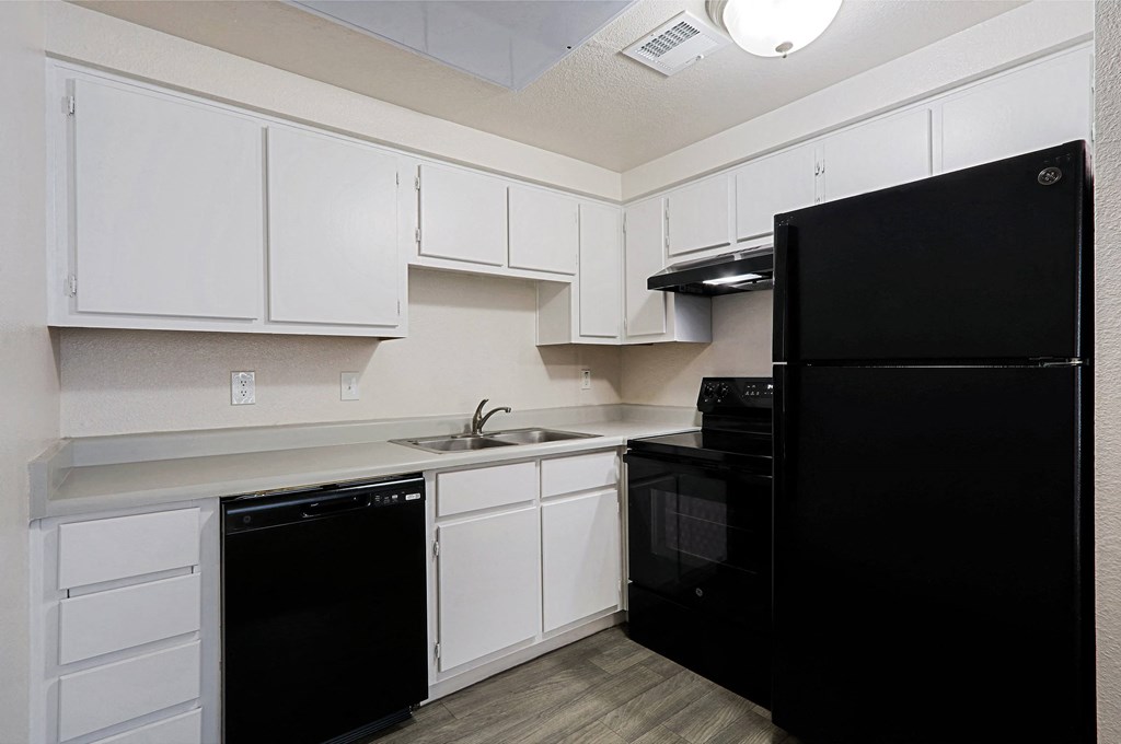 a kitchen with black appliances and white cabinets