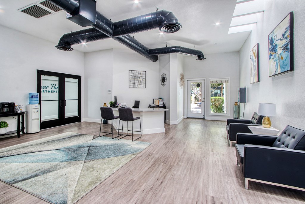 a living room with couches and chairs and a ceiling fan