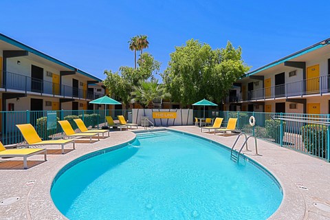 Outdoor pool with lounge chairs and umbrellas at The Link Apartments, Mesa, 85201