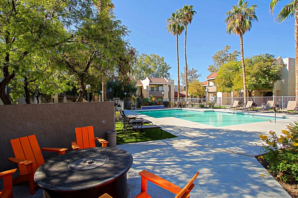 our apartments have a pool and a patio with chairs and a table