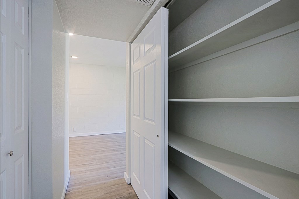 A white door is open to a room with shelves.