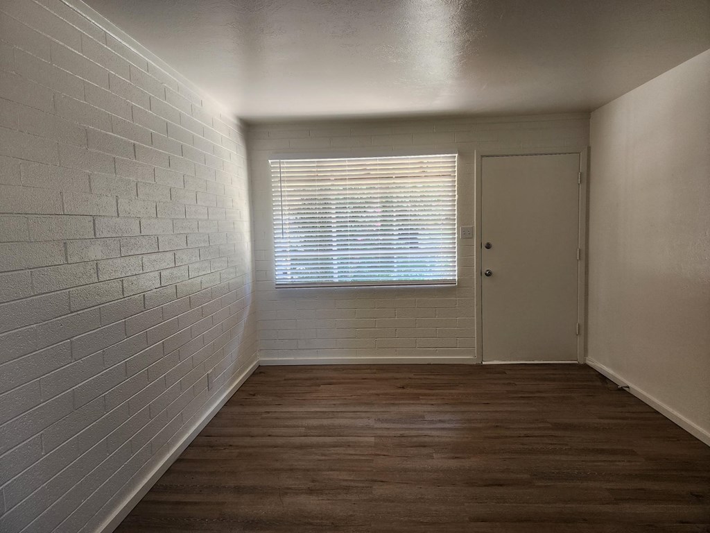an empty room with a window and a door
