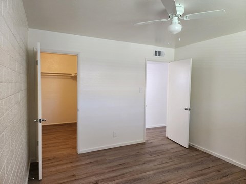 a bedroom with a closet and a ceiling fan