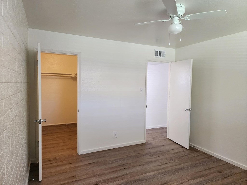 a bedroom with hardwood floors and a ceiling fan