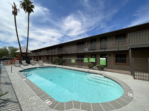 A swimming pool in a resort with a clear blue sky.