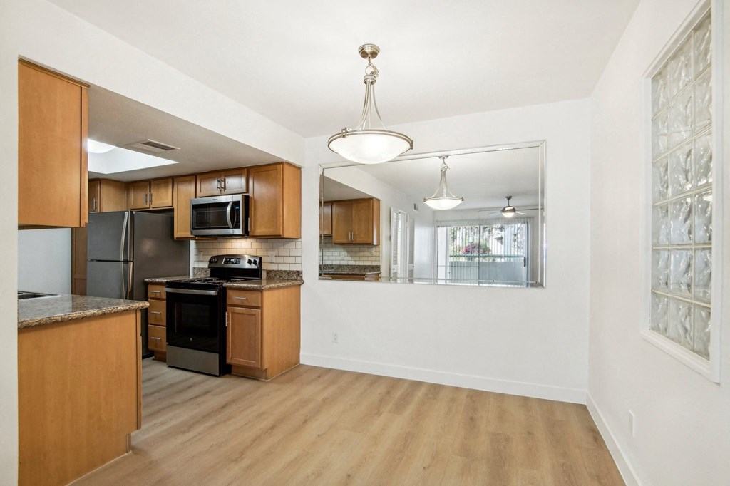 A kitchen with wooden cabinets and a black stove top oven. at The Viridian, Scottsdale