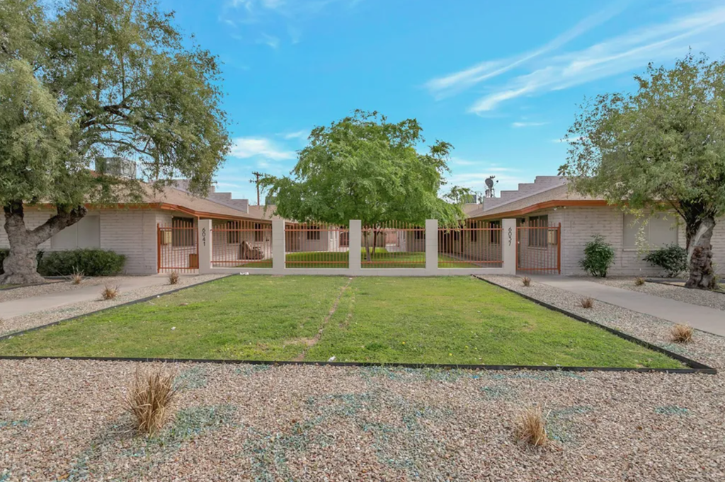 a yard in front of a house with a lawn and trees