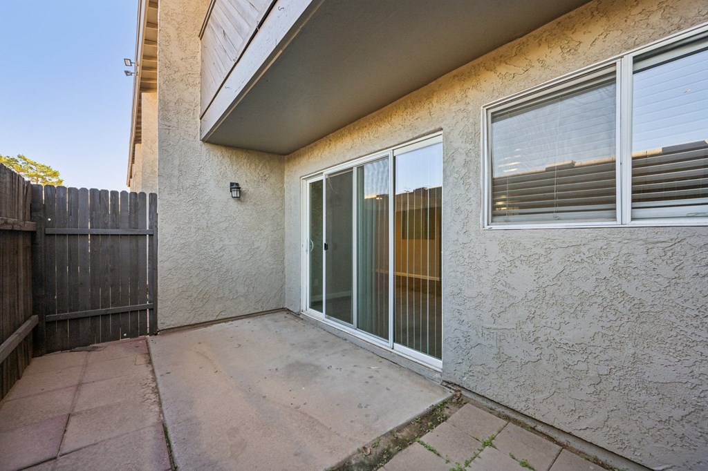 A patio area of a house with a sliding glass door.