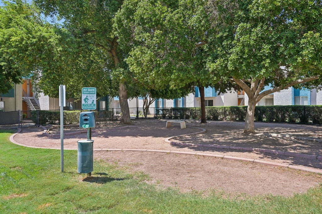 A green sign with a white arrow pointing to the right stands in a grassy area.