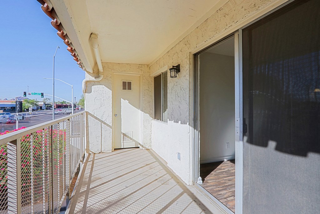 A balcony with a railing and a view of the street below.