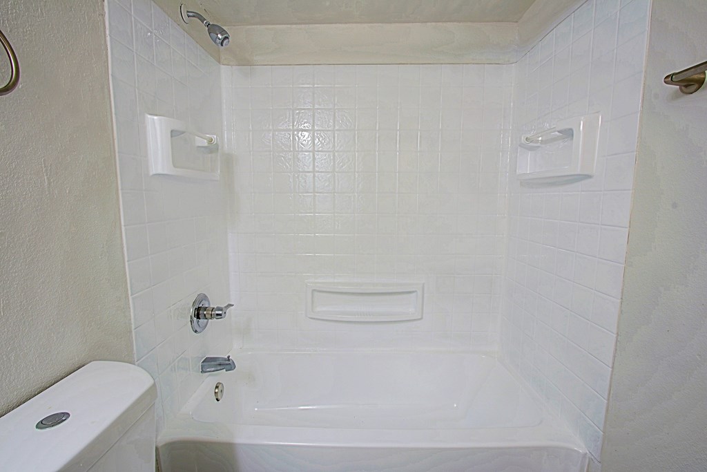 A white bathroom with a tub, toilet and sink at Aspire Mesa,  Arizona.