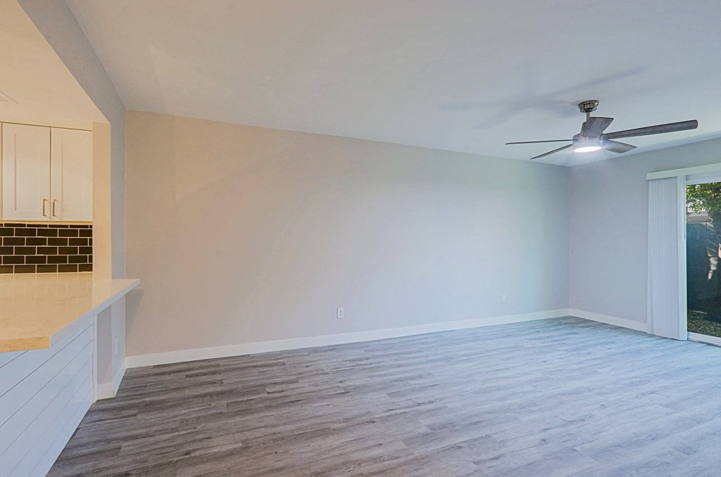 A room with a ceiling fan and a window.