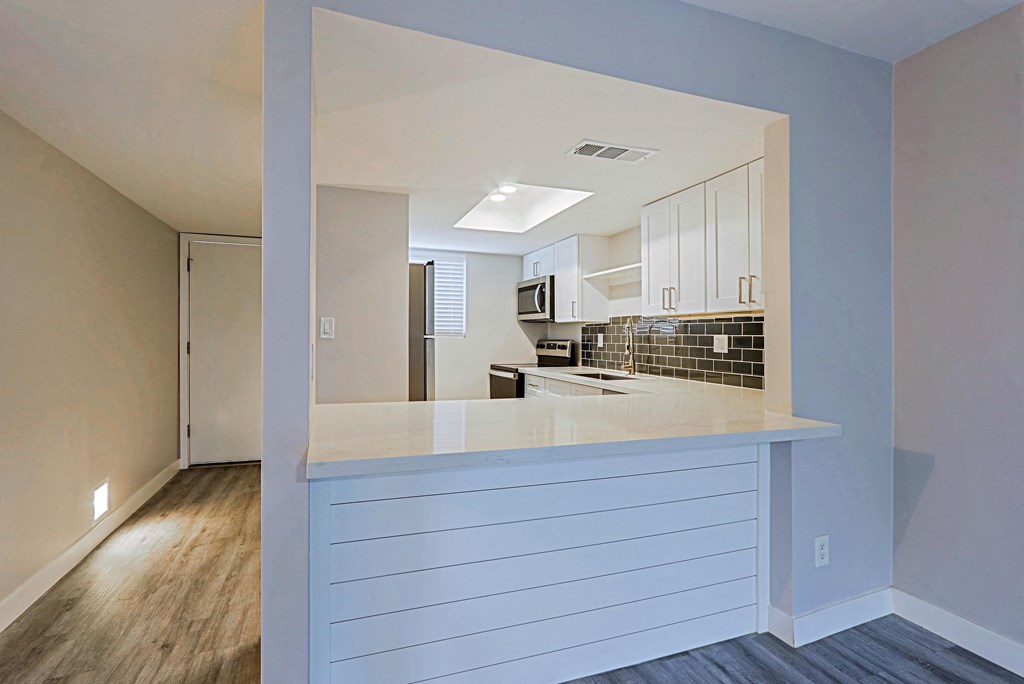 A kitchen with white cabinets and a countertop.