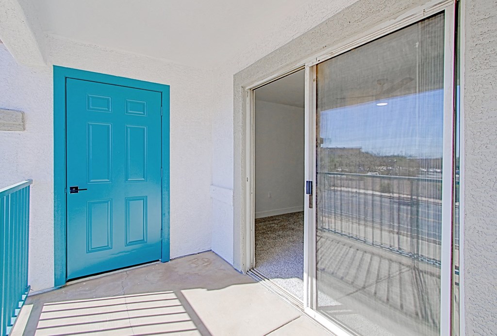 a blue door on a patio in a room with a balcony