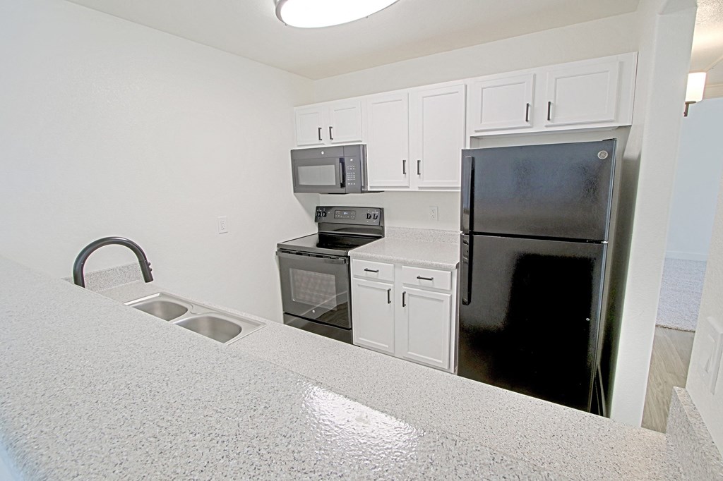 a kitchen with stainless steel appliances and white cabinets