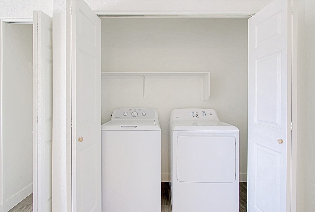 an empty laundry room with two washes and a dryer
