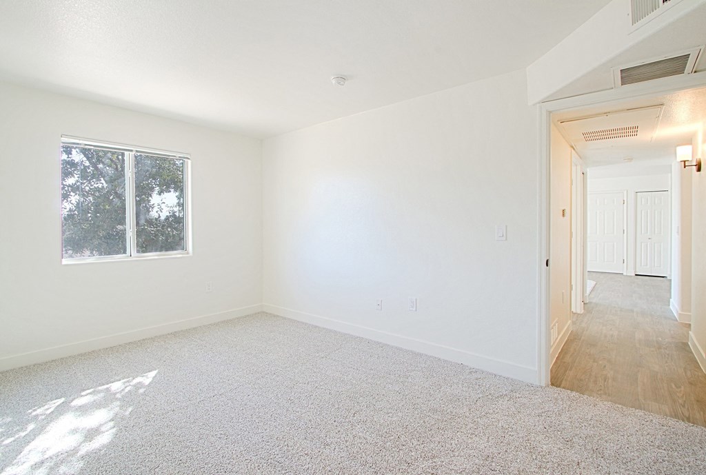 an empty room with white walls and a window