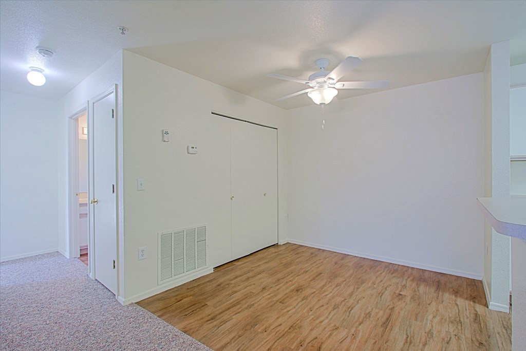A room with a ceiling fan and a door.