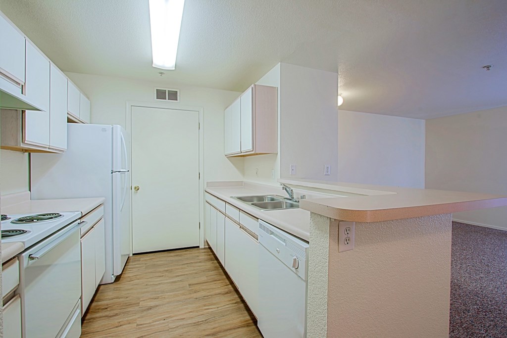 A kitchen with white appliances and cabinets.
