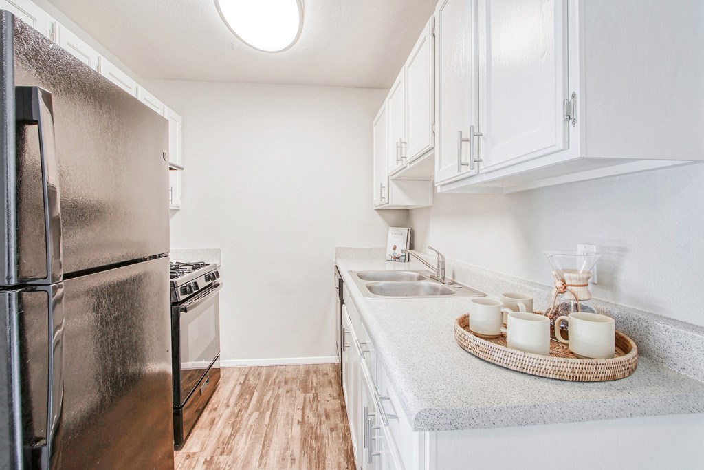 a renovated kitchen with stainless steel appliances and white cabinets