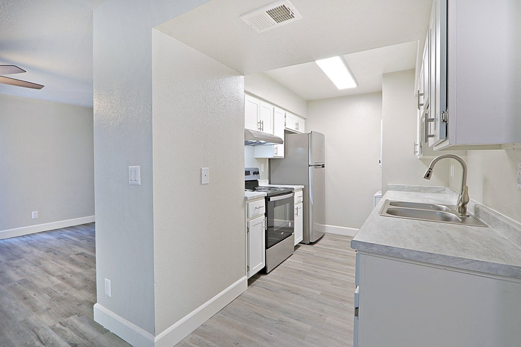 an empty kitchen with a sink and a refrigerator
