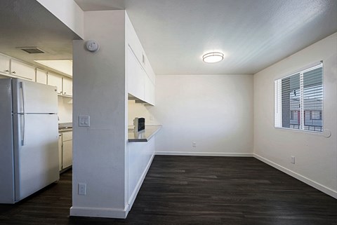 A kitchen with a refrigerator and a countertop with a window.