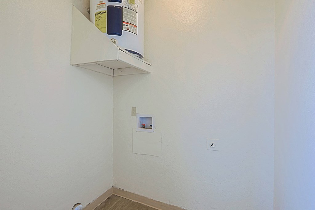an empty room with a white wall and a shelf on the wall