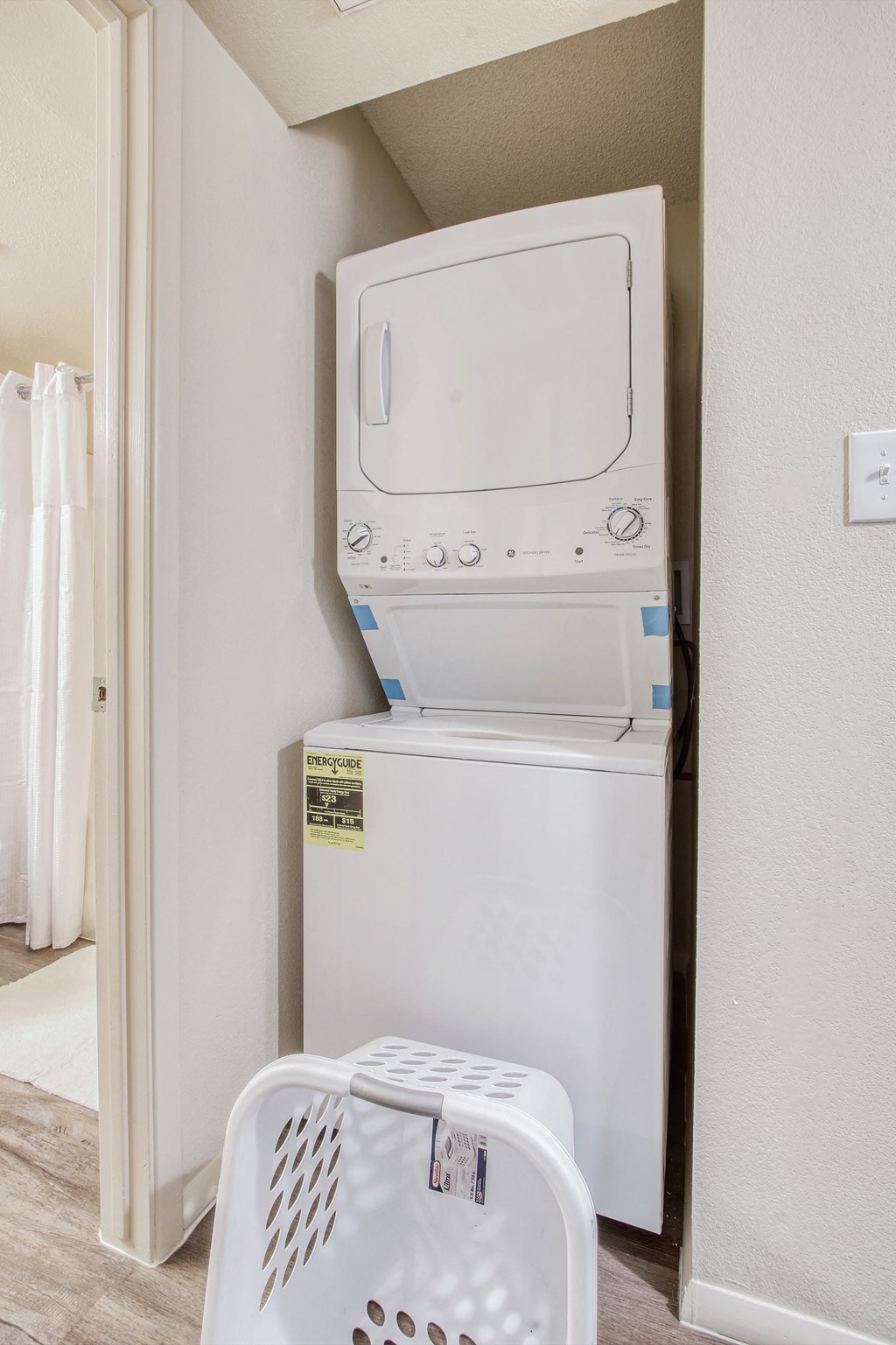 a white washer and dryer in a room with a laundry basket