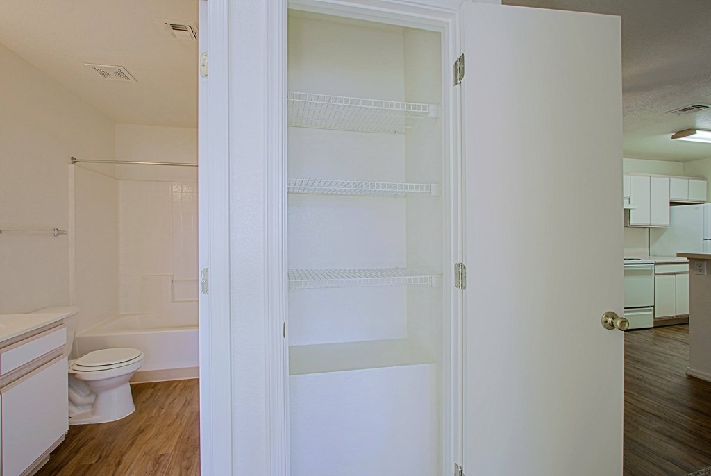 A white door is open to a room with a toilet and a sink.