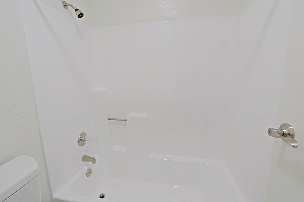 a white bathroom with a shower and a toilet