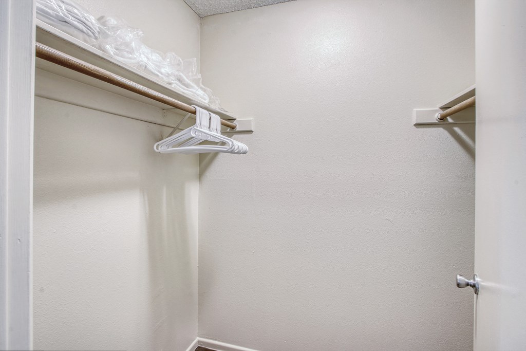 an empty closet in a room with a hanger on the wall
