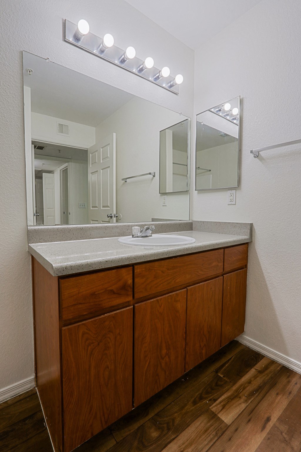 A bathroom vanity with a sink and mirror.