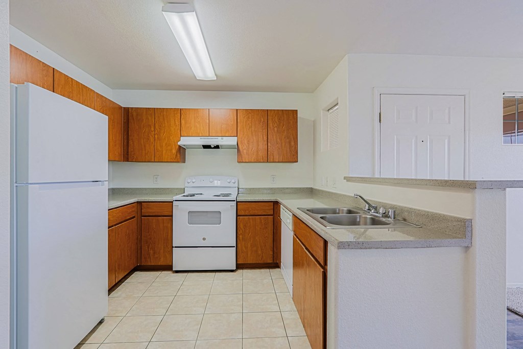 A kitchen with white appliances and wooden cabinets.