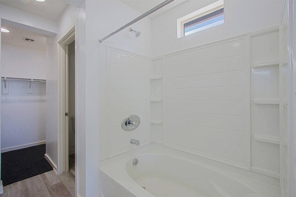 a white bathroom with a tub and a shower