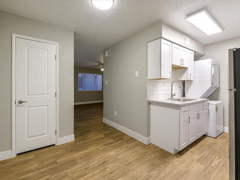 an empty kitchen with a sink and a refrigerator